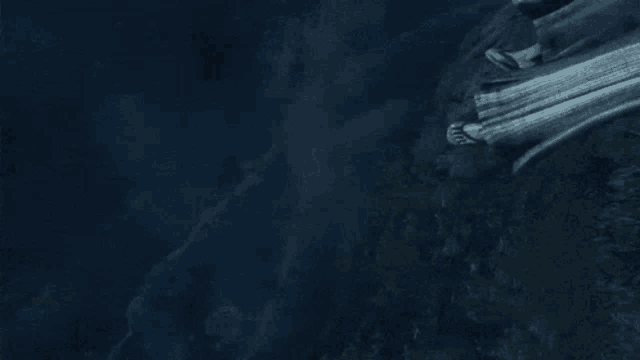 an aerial view of a waterfall in the middle of a dark forest at night .