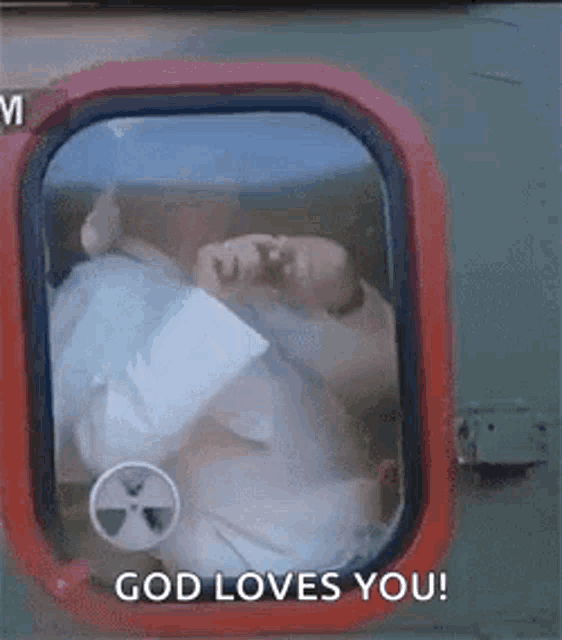 a man is looking out of a window with the words `` god loves you '' on it .
