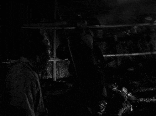 a black and white photo of two men talking to each other