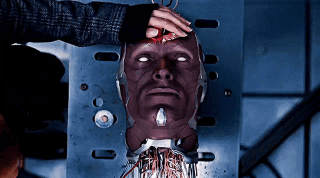 a person is touching a robot 's head with a scissor .