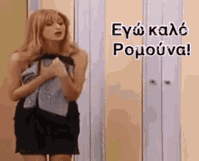 a woman wrapped in a towel is standing in front of a closet with greek writing on it .