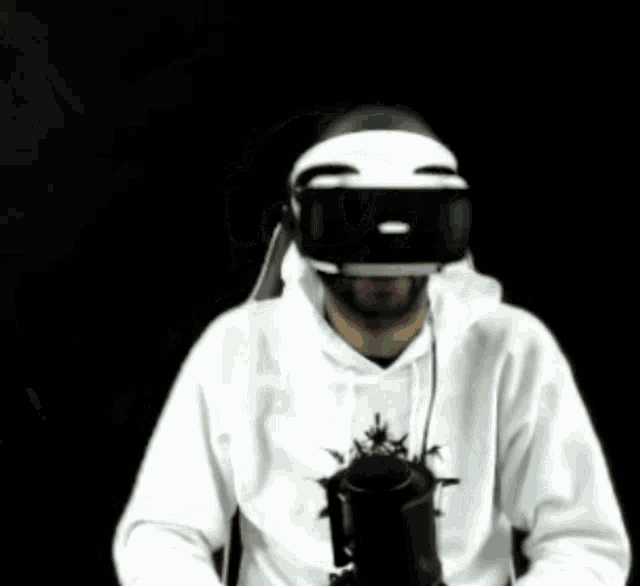 a man wearing a mask and headphones is holding a gun in his hand .