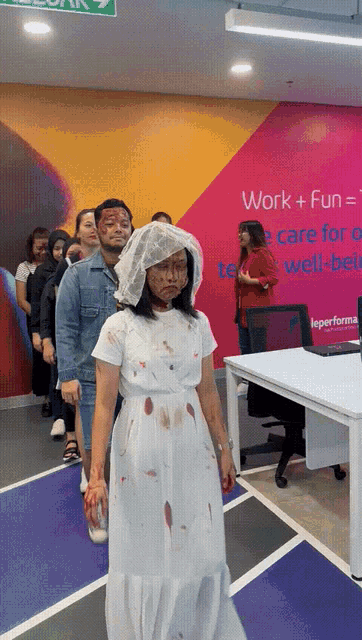 a woman in a white dress with blood on her face stands in front of a sign that says work + fun