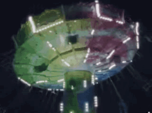 a blurred image of a colorful circle with lights on it in the dark