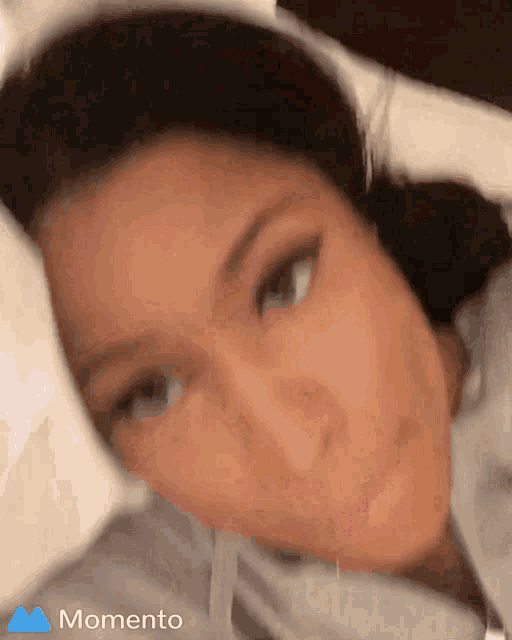 a close up of a woman 's face with the word momento in the upper right corner