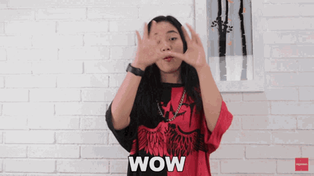 a woman wearing a red and black shirt with the word wow on it