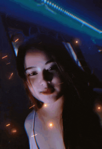a girl wearing headphones is standing in front of a blue light