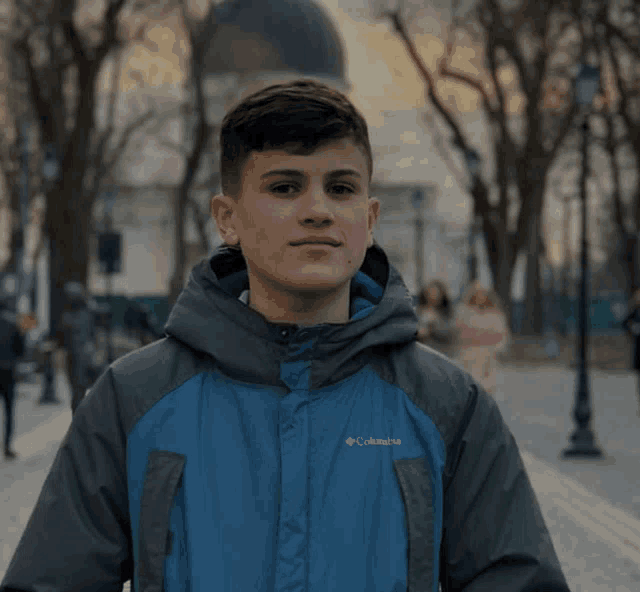 a young man wearing a blue columbia jacket