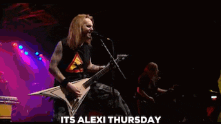 a man is playing a guitar and singing into a microphone while another man plays a guitar .