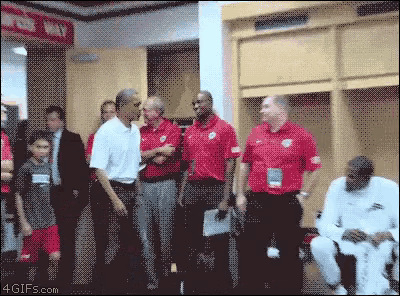 a group of men in red shirts are standing in a locker room with a sign that says ' locker way '