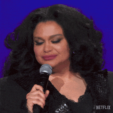 a woman singing into a shure microphone with the netflix logo in the corner