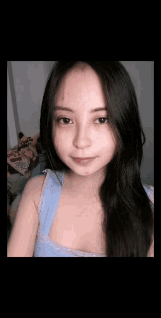 a young woman with long dark hair is taking a selfie