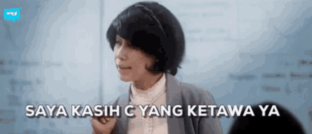 a woman in a classroom with the words saya kasih c yang ketawa ya written below her