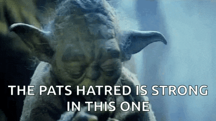 a close up of a statue of yoda with the words `` the pats hatred is strong in this one '' written on it .