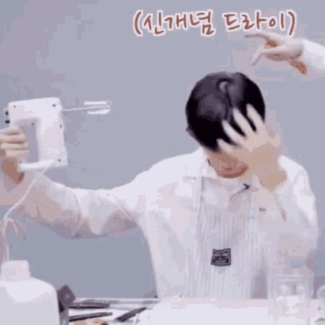 a man in an apron is holding a hand mixer in his hand