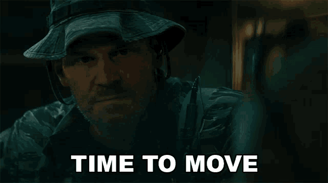 a man in a hat says time to move in a dark room