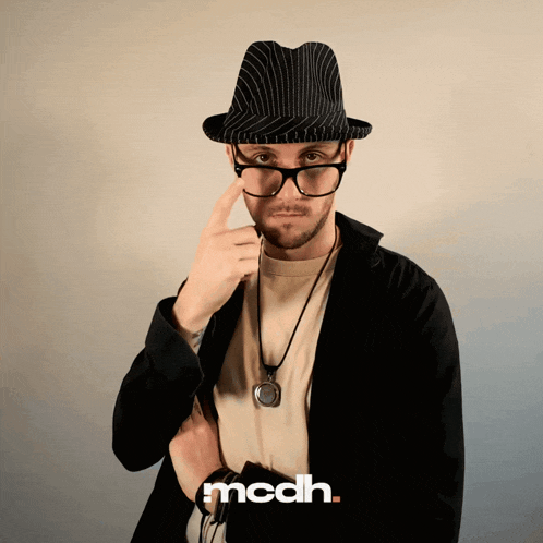 a man wearing glasses and a hat with the word mcdh on the bottom
