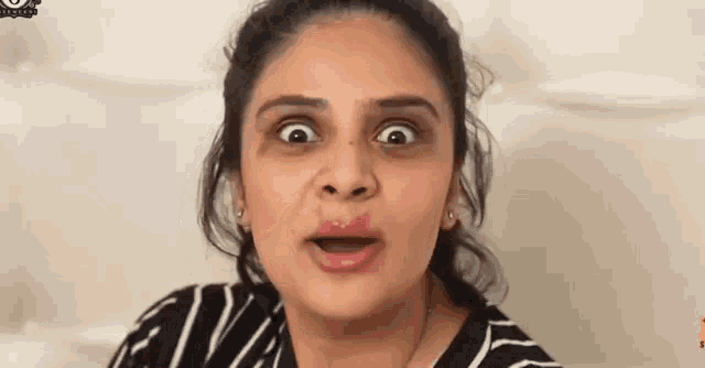 a woman is making a funny face with her mouth open and lipstick on her lips .