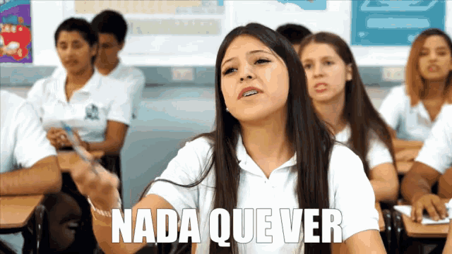a girl sitting in a classroom with the word nada que ver above her