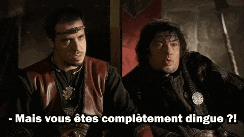 two men are sitting next to each other and talking in a castle .