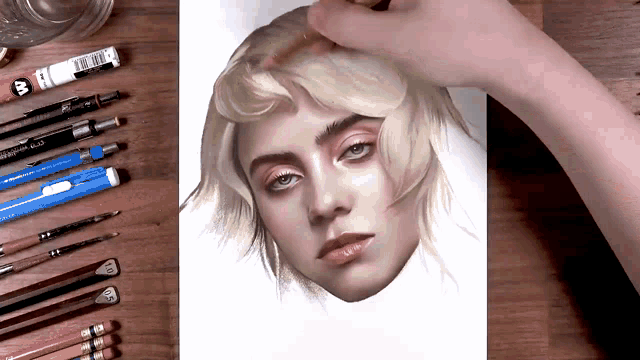 a person is drawing a woman 's face with a pencil that has the letter b on the eraser