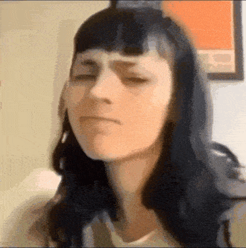 a woman with long black hair is making a funny face