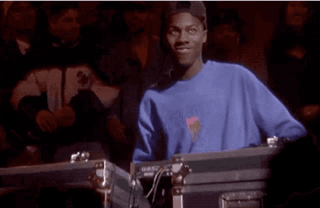 a man in a blue sweatshirt is standing in front of a case .