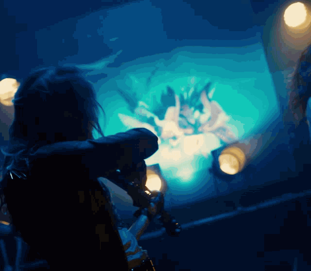 a person in a dark room looking at a painting