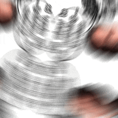 a stack of silver coins is spinning on a white surface