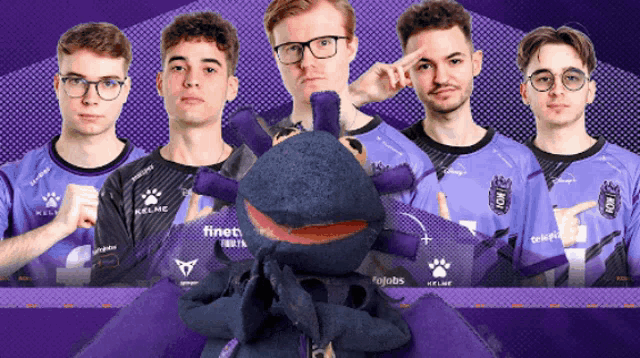 a group of young men are posing for a picture with a stuffed animal that says finet on it