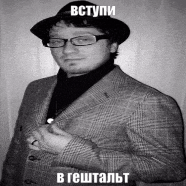 a black and white photo of a man in a suit and hat with the caption " вступи " above him