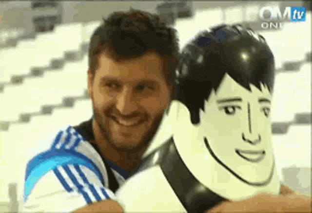 a man with a beard is smiling while holding an inflatable man 's head