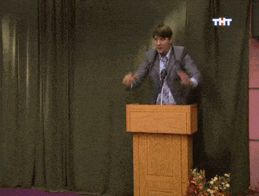 a man and a woman are dancing in front of a podium with tht written on it