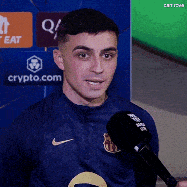 a man is talking into a microphone while wearing a nike shirt
