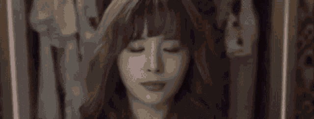 a close up of a woman 's face with her eyes closed and her hair blowing in the wind .