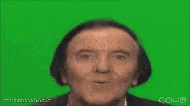 a man with a surprised look on his face is making a funny face on a green screen .