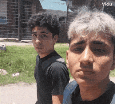 two young men are standing next to each other and one has a backpack on his back ..