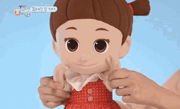 a person is holding a stuffed doll with chinese writing on the bottom