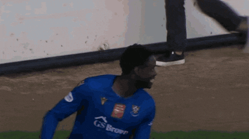a man wearing a blue gs brown jersey is running on a soccer field