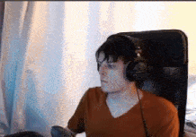 a young man wearing headphones is sitting in a chair .