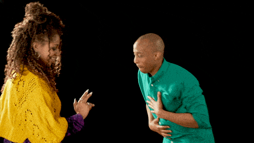 a man in a green shirt and a woman in a yellow sweater are dancing