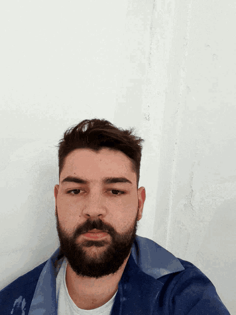 a man with a beard wearing a blue jacket