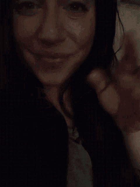 a close up of a woman 's face with a hand on her chin