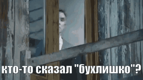 a man in a suit is looking out of a window with a wooden fence .