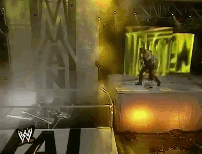 a man stands on a stage in front of a large screen that says monster