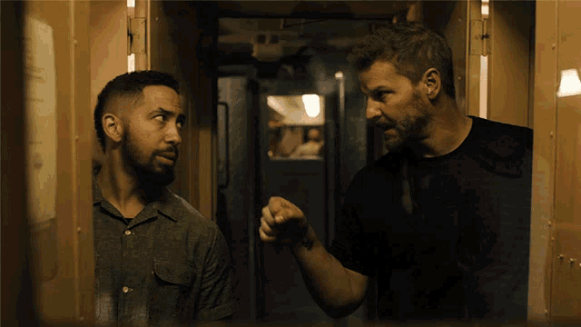 two men are standing next to each other and one is pointing