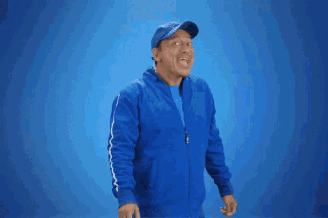 a man wearing a blue jacket and hat is waving his hand
