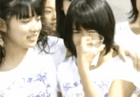 a group of young girls are posing for a picture and one girl is drinking a glass of milk .