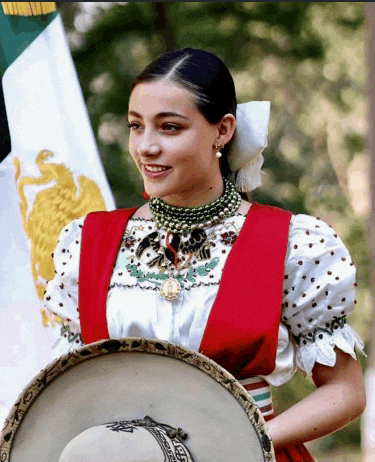 a woman in a mexican outfit holds a sombrero