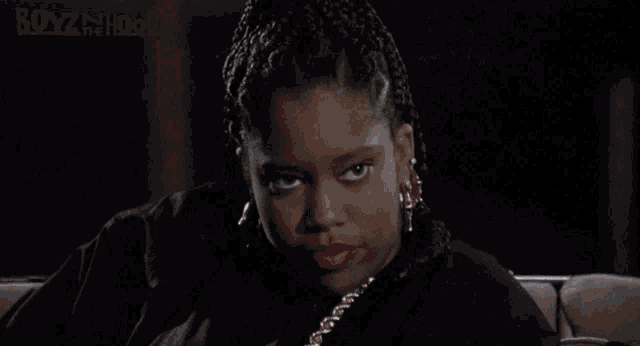 a woman is sitting on a couch with the words boyz in the hood on the bottom